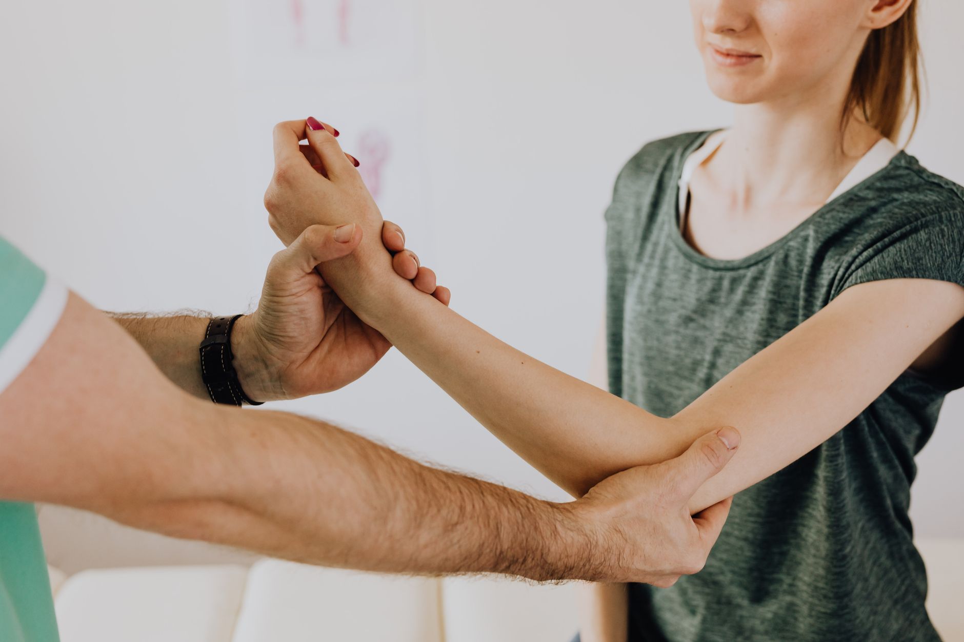 Therapeutin untersucht das Armgelenk einer Patientin